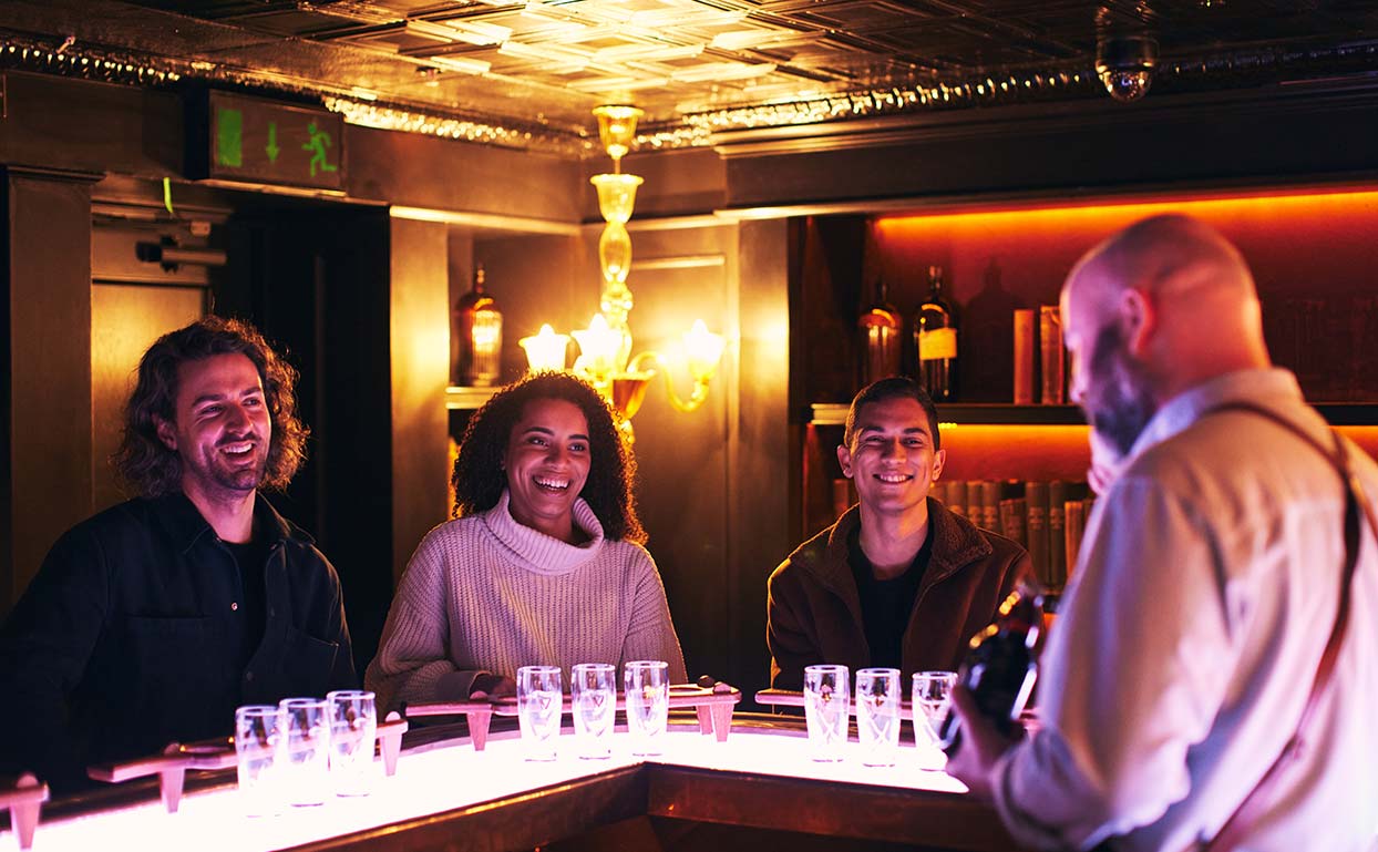 Three people sitting at the bar in the Connoisseur room at the Guinness Storehouse 